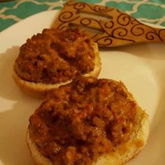 two pieces of bread with meat on them sitting on a plate next to a banana