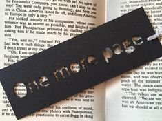 a bookmark with the word docc on it laying next to an open book