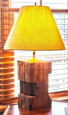 a lamp that is sitting on top of a wooden table in front of a window