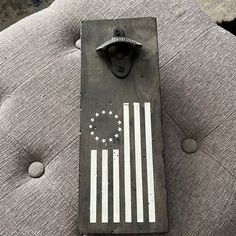 an american flag painted on the back of a gray couch with buttons and a bottle opener