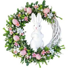 a white rabbit sitting in front of a wreath with pink flowers and greenery on it