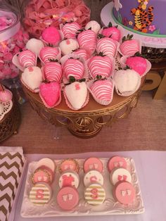 pink and white cupcakes are arranged on a table