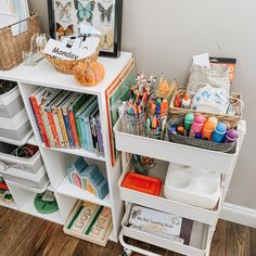 a white book shelf filled with lots of books and crafting supplies on top of it