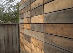 a wooden fence next to a tree with no leaves on the top and bottom half