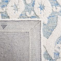 the corner of a rug with blue and white designs on it's edges is shown in close up