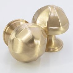 two shiny brass knobs on white background