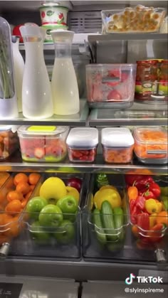 an assortment of fruits and vegetables on display in a store freezer with milk jugs