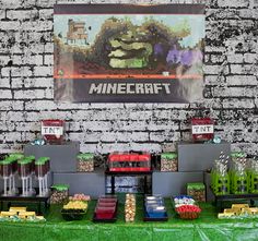 a table topped with lots of desserts next to a brick wall covered in green grass