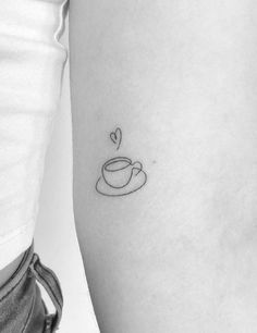 a woman's arm with a coffee cup tattoo on the left side of her body