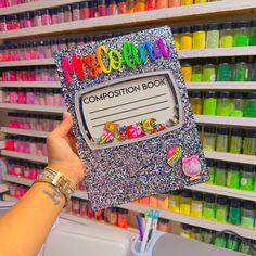 a person holding up a book with writing on it in front of a store shelf