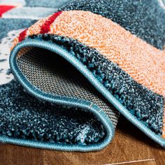 a blue and orange rug on top of a wooden floor