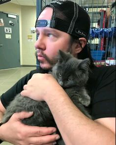 a man is holding a cat in his arms