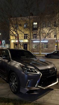 two cars are parked on the side of the road at night in front of some buildings