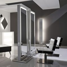 a modern bathroom with mirrored walls and white furniture on the floor, along with black and white decor