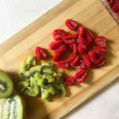 sliced kiwis and strawberries on a cutting board