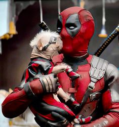 two people dressed as deadpools and one is holding a dog in his arms