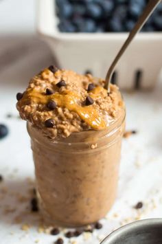 a glass jar filled with oatmeal topped with chocolate chips and caramel