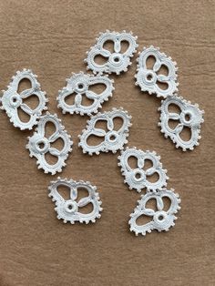 six silver metal gears on a brown background