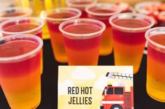 red hot jellies in plastic cups on a table with a sign that says, red hot jellies