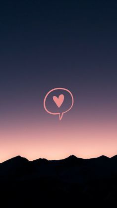 a pink heart in the middle of a purple sky with mountains and hills behind it