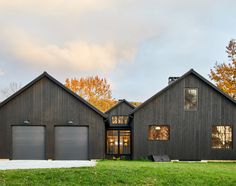 a black house with two garages and windows