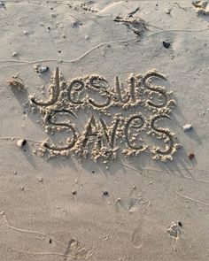 the words jesus loves me written in sand