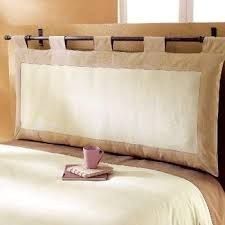 a bed with two pillows on top of it and a cup next to the pillow