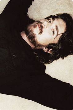 a man with long hair laying on the floor