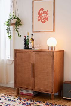 a wooden cabinet sitting next to a window filled with bottles and glasses on top of a rug