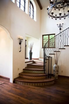 an elegant staircase with wrought iron railing and wood flooring