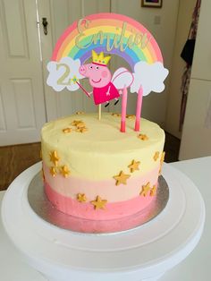 a pink and yellow cake with a peppa pig on top