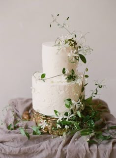 a wedding cake with white flowers and greenery