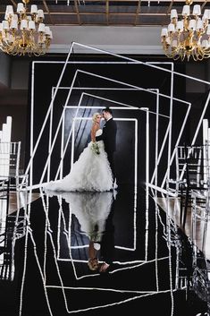 a woman standing in front of a mirror with white lines on the floor and chandelier