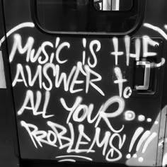 graffiti on the side of a bus door that says music is the answer to all your problems