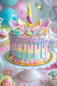 a birthday cake decorated with rainbow icing and sprinkles on a table