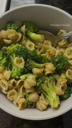 a white bowl filled with pasta and broccoli