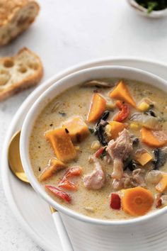 a white bowl filled with soup next to bread