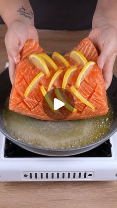 someone is cooking salmon and lemons on the stove