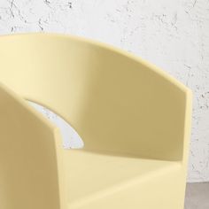 a yellow chair sitting in front of a white wall