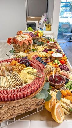 a long table filled with lots of different types of cheeses and meats on it