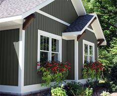 a house with flowers in the window boxes on the front and side of the house