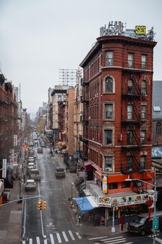 a city street filled with lots of traffic and tall red buildings next to each other