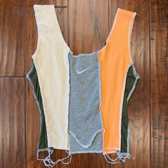 three different colored vests sitting on top of a wooden floor next to each other