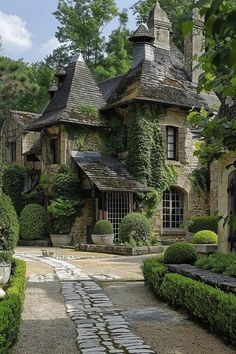 an old stone house is surrounded by greenery