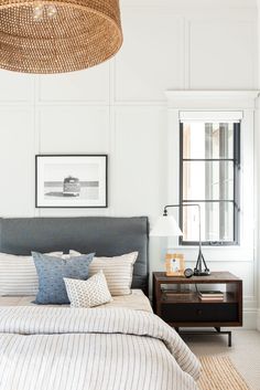 a bedroom with white walls and striped bedding