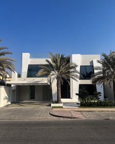 a large white building with palm trees in front of it