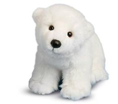 a white stuffed polar bear sitting on the ground