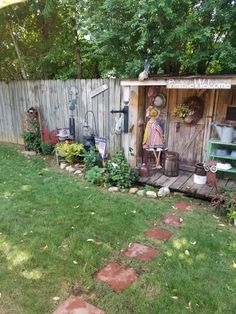 a garden shed with pots and gardening equipment in it's back yard, next to a brick path