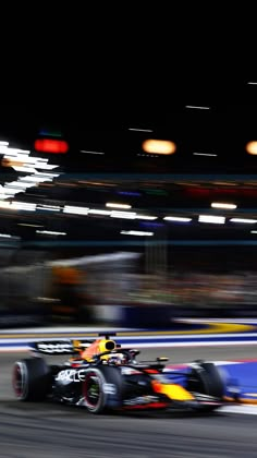 a red bull racing down the track at night