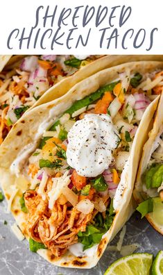 shredded chicken tacos with sour cream on top and lime wedges around the edges